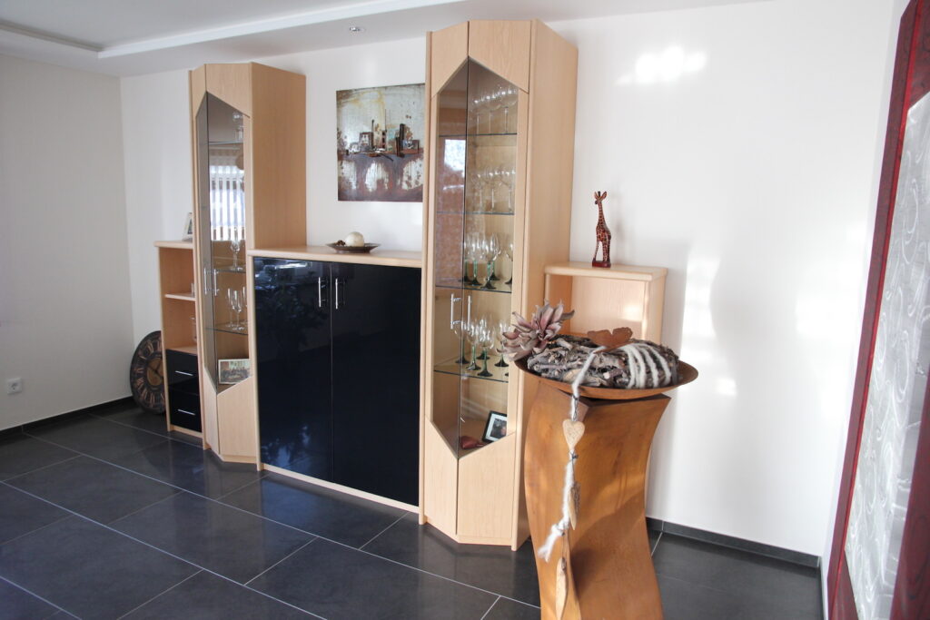 Wohnzimmer in Eiche mit schwarzer Hochglanz Front